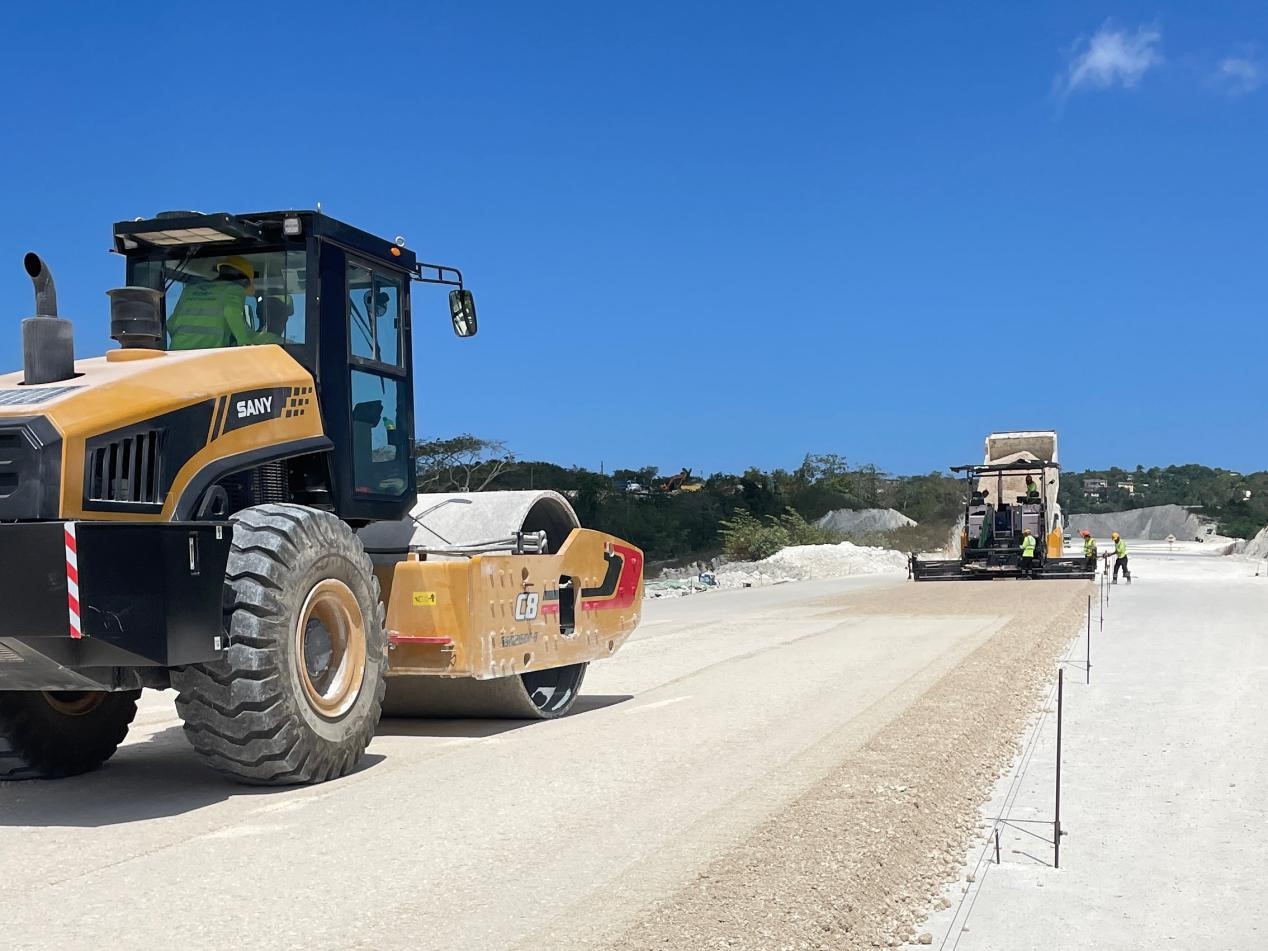 圖為中企承建的牙買加蒙特哥貝繞城路項(xiàng)目基層試驗(yàn)段正在進(jìn)行攤鋪和碾壓施工，相關(guān)施工工作已于日前順利完成。中國港灣美洲區(qū)域公司供圖