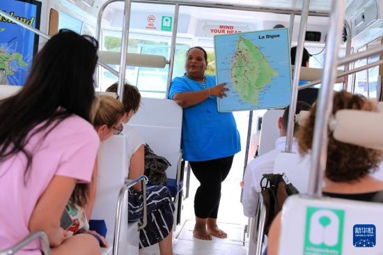 3月15日，一名導(dǎo)游在游艇上為游客介紹塞舌爾拉迪格島。新華社記者 董江輝 攝