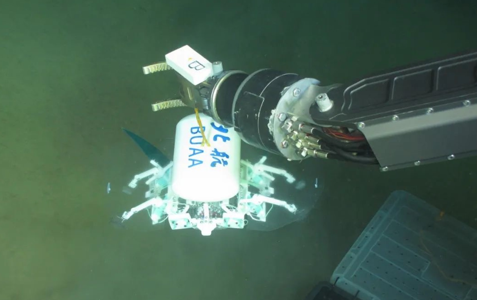 科研人員利用機(jī)械臂將北航深海小型機(jī)器人投于馬里亞納海溝。校方供圖