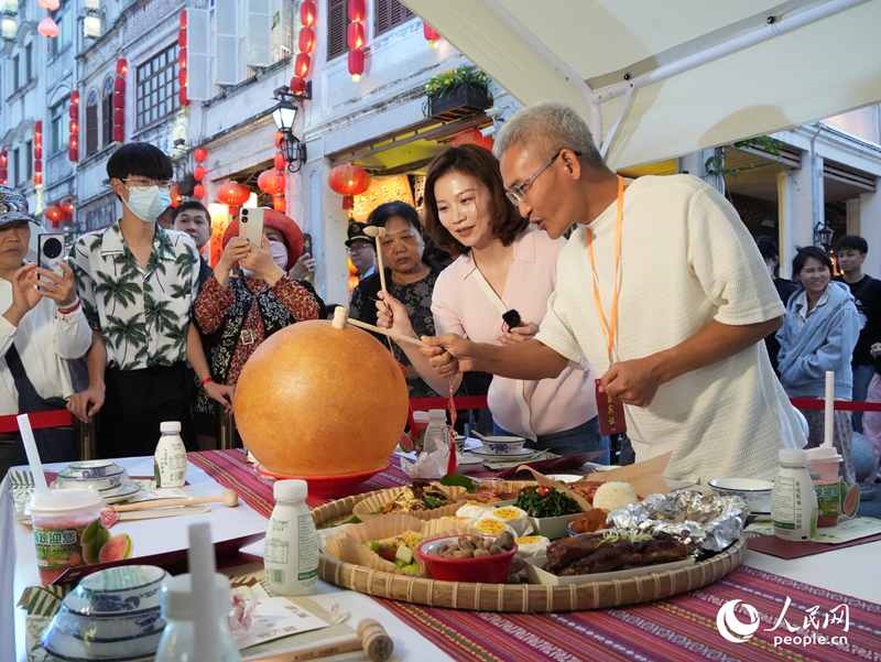 嘉賓品嘗海南傳統(tǒng)美食“煎堆”。人民網(wǎng)記者 張力洋攝