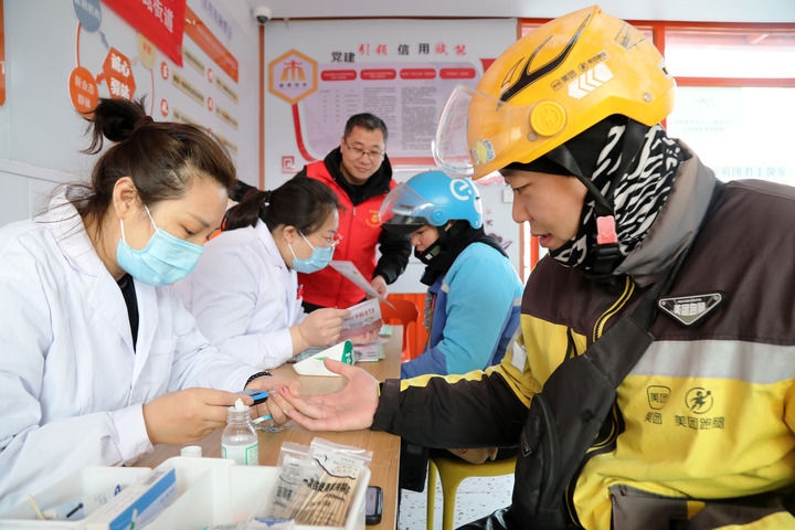 2025年3月5日，志愿者在山東省棗莊市市中區(qū)一工會驛站為外賣員免費(fèi)測量血糖。新華社發(fā)（王海楠攝）