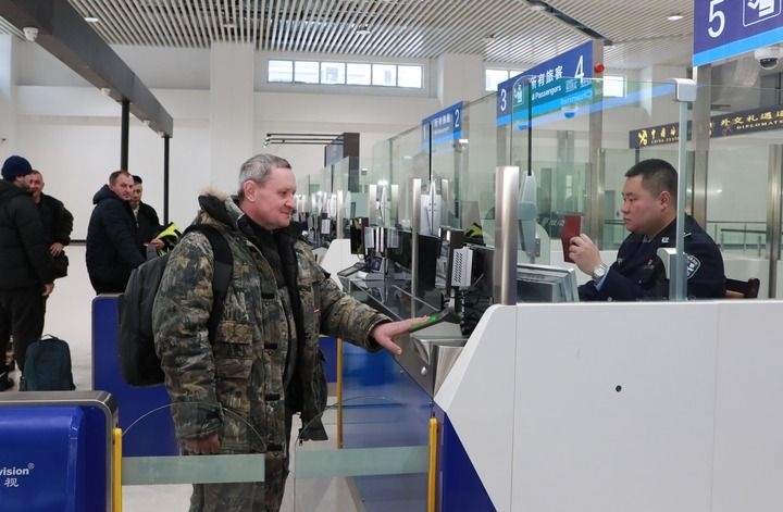 2024年12月10日，在黑河公路口岸旅檢大廳，黑河出入境邊防檢查站民警為首班次客車入境旅客辦理邊檢通關(guān)手續(xù)。當日，中國黑河公路口岸—俄羅斯卡尼庫爾干公路口岸旅客運輸正式開通。新華社發(fā)（劉松攝）