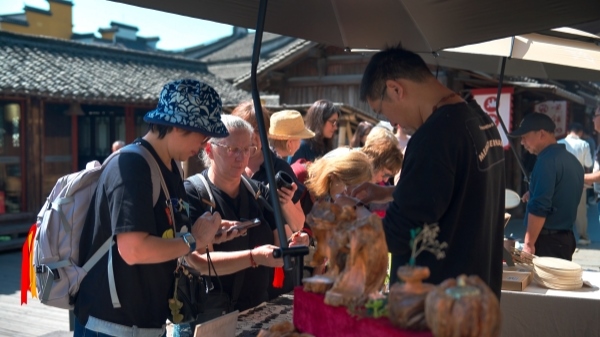 “五一”期間，游客正在烏鎮(zhèn)“水鄉(xiāng)碼頭”挑選購買文創(chuàng)產(chǎn)品。受訪者供圖