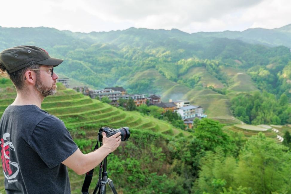 2025年年5月9日，廣西桂林，外國游客游覽龍脊梯田，在美景前駐足拍照。（圖片來源：視覺中國）