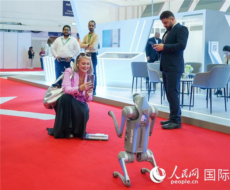 與會(huì)嘉賓被中企機(jī)器人吸引。人民網(wǎng) 塔里克·易卜拉欣攝
