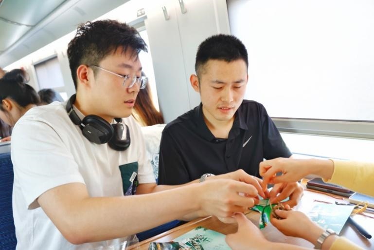 G232次旅客親手制作端午荷包和五彩繩。王磊攝