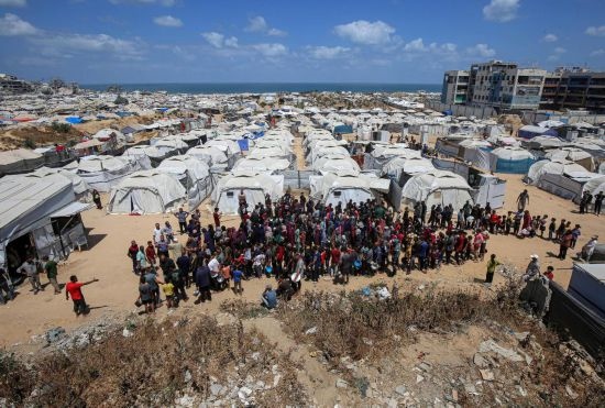 5月28日，人們在加沙城西部的沙提難民營等待領(lǐng)取救助食物。新華社發(fā)（里澤克·阿卜杜勒賈瓦德攝）