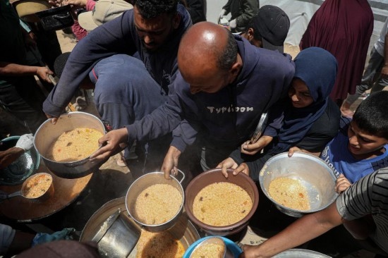 5月28日，人們在加沙城西部的沙提難民營領(lǐng)取救助食物。新華社發(fā)（里澤克·阿卜杜勒賈瓦德攝）