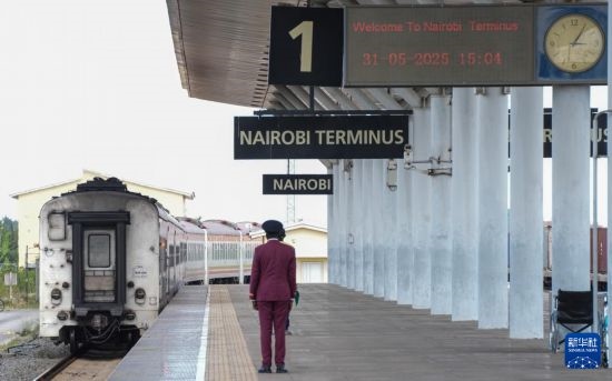 5月31日，在蒙內(nèi)鐵路內(nèi)羅畢站，工作人員目送開往蒙巴薩的E2次列車駛離站臺。新華社記者 李亞輝 攝
